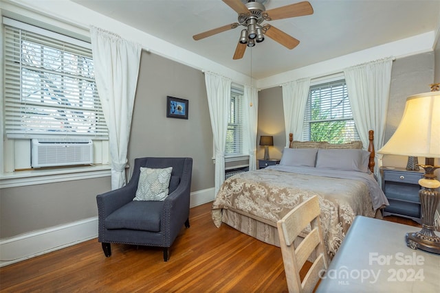 bedroom with ceiling fan, cooling unit, and dark wood-type flooring