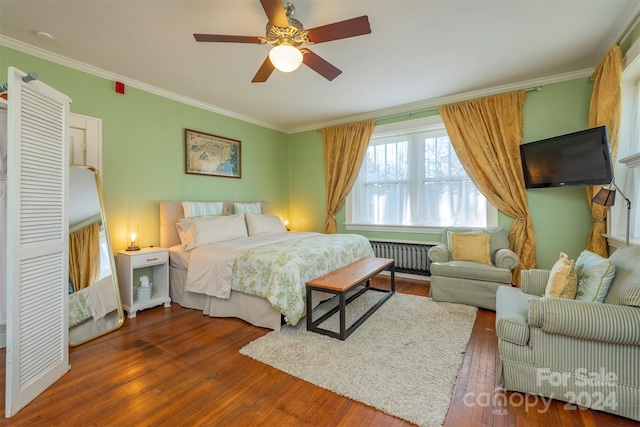 bedroom with radiator heating unit, dark hardwood / wood-style floors, ceiling fan, and ornamental molding