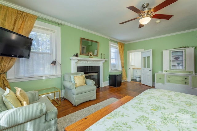 bedroom featuring multiple windows, crown molding, and dark hardwood / wood-style flooring