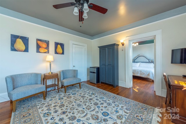 living area with ceiling fan and dark hardwood / wood-style floors