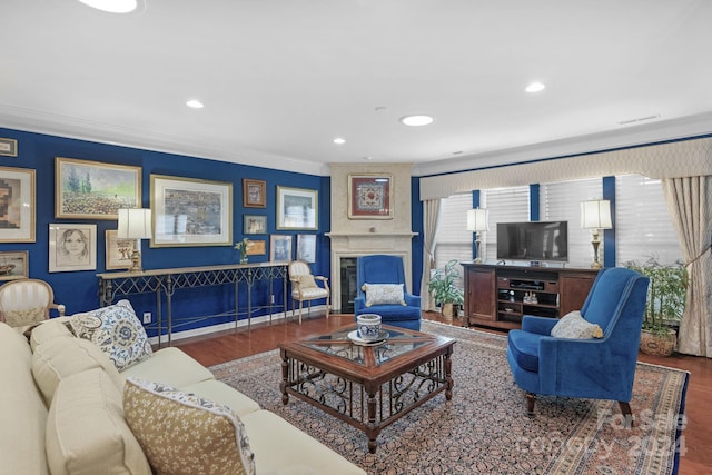 living room featuring dark hardwood / wood-style floors, a large fireplace, and ornamental molding