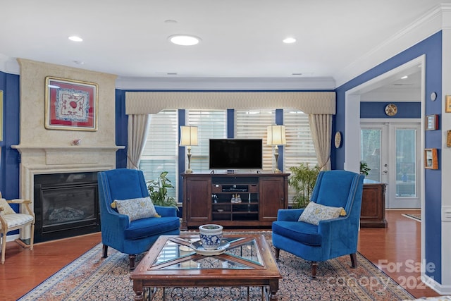 living room with ornamental molding, a fireplace, wood-type flooring, and french doors