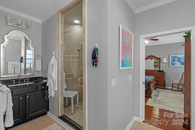 bathroom featuring hardwood / wood-style floors, vanity, ceiling fan, crown molding, and a shower with shower door