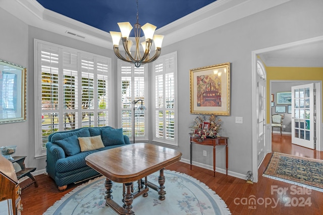 sitting room with dark wood-type flooring, a wealth of natural light, a chandelier, and ornamental molding