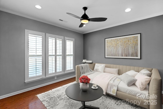 living room with baseboards, crown molding, visible vents, and wood finished floors