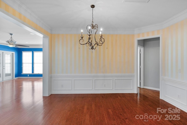 unfurnished dining area featuring ornamental molding, wood finished floors, and wallpapered walls