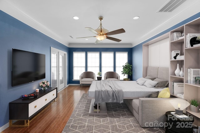 bedroom featuring ornamental molding, dark wood-style flooring, visible vents, and baseboards