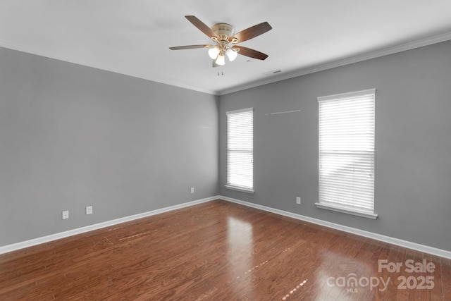 spare room featuring ornamental molding, ceiling fan, baseboards, and wood finished floors