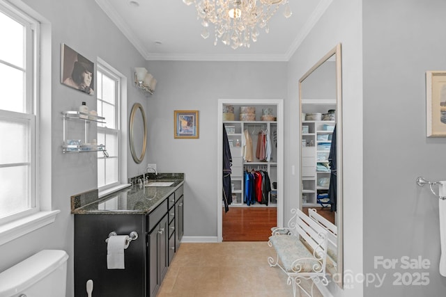 bathroom with ornamental molding, tile patterned flooring, a spacious closet, and toilet