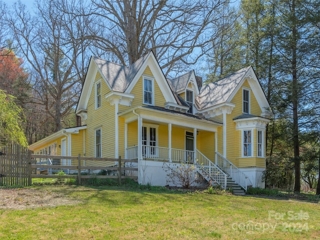 victorian house featuring a front lawn and covered porch