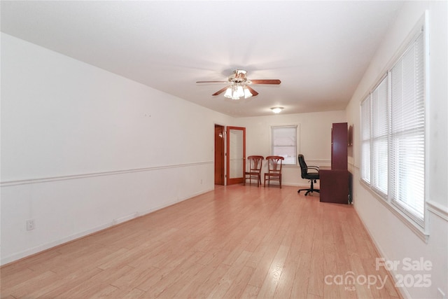 unfurnished office with ceiling fan and light wood-type flooring