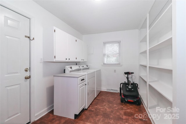 clothes washing area featuring independent washer and dryer and cabinets