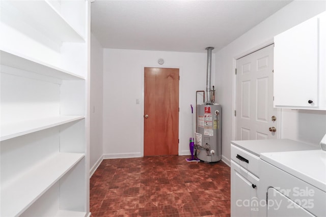 laundry area featuring water heater, cabinets, and washer and clothes dryer