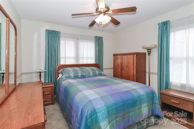 carpeted bedroom with ceiling fan and a closet