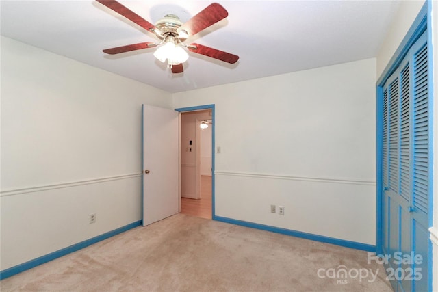 unfurnished bedroom featuring a closet, light colored carpet, and ceiling fan