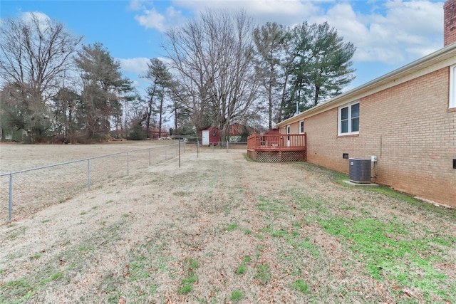 view of yard with central AC unit and a deck