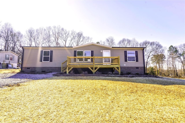 manufactured / mobile home with a front lawn and a wooden deck