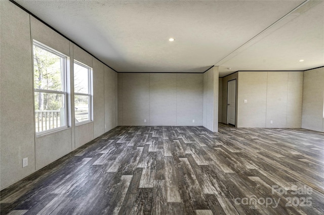 empty room featuring dark hardwood / wood-style flooring and a textured ceiling