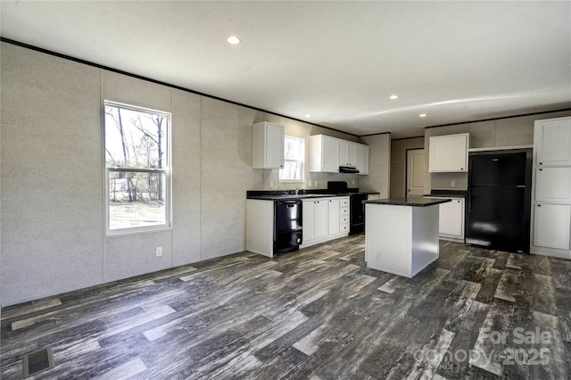 kitchen with black appliances, a center island, dark hardwood / wood-style flooring, and white cabinetry