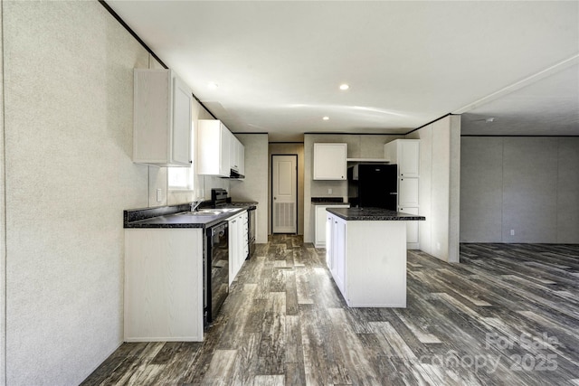 kitchen featuring black appliances, a kitchen island, dark hardwood / wood-style flooring, and white cabinetry