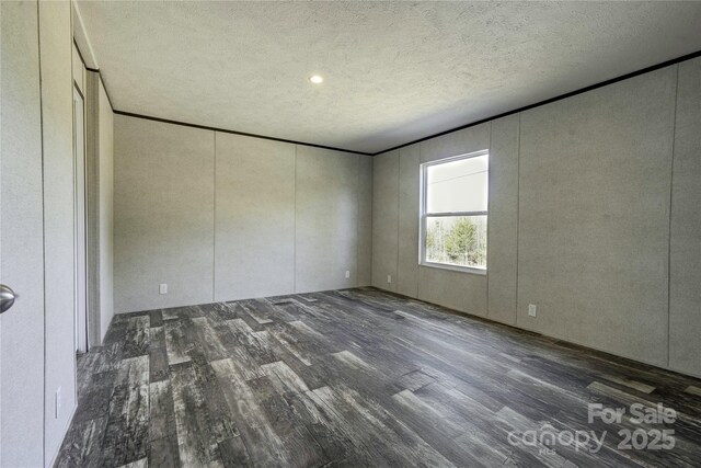 unfurnished bedroom with dark hardwood / wood-style floors and a textured ceiling