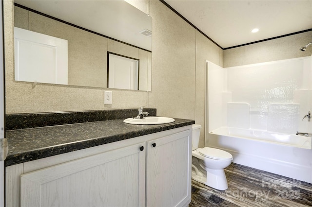 full bathroom with tub / shower combination, hardwood / wood-style floors, toilet, vanity, and ornamental molding