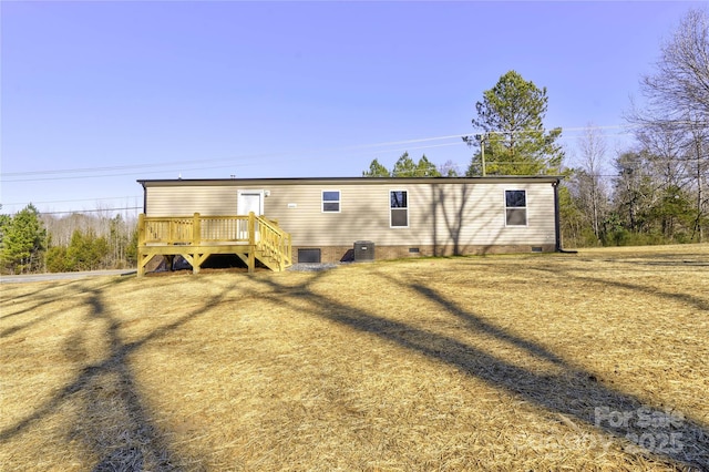 back of house featuring central air condition unit and a wooden deck