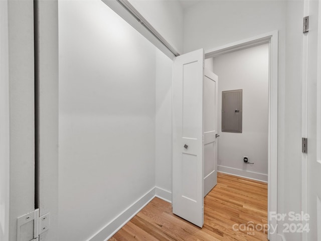 laundry room with electric panel and wood-type flooring