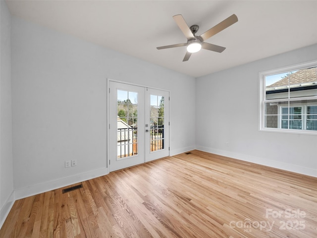 spare room with light wood-type flooring, french doors, baseboards, visible vents, and ceiling fan
