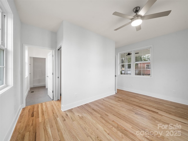 unfurnished room featuring baseboards, light wood-type flooring, and a ceiling fan