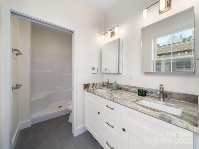bathroom with toilet, tile patterned floors, a sink, a stall shower, and double vanity