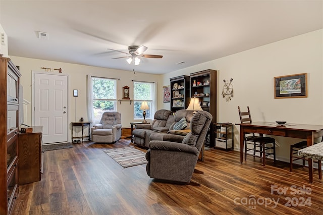 living room with dark wood-type flooring and ceiling fan