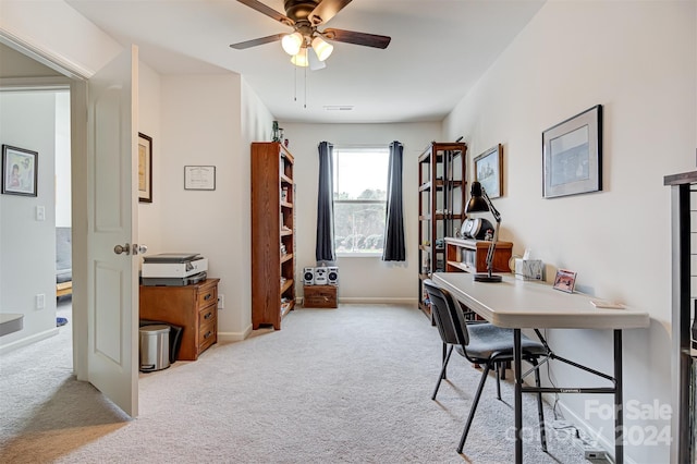 carpeted office space featuring ceiling fan