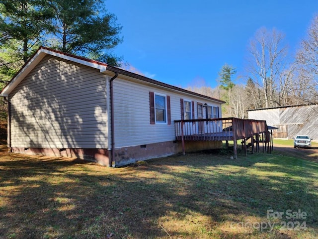 back of property featuring a deck and a yard