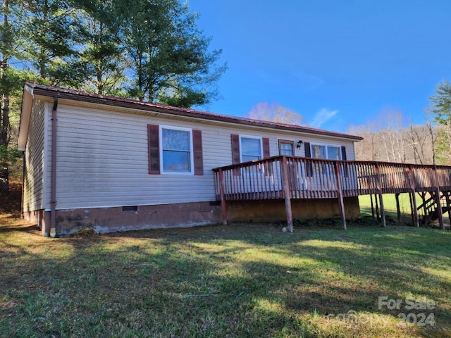 back of house featuring a yard and a wooden deck