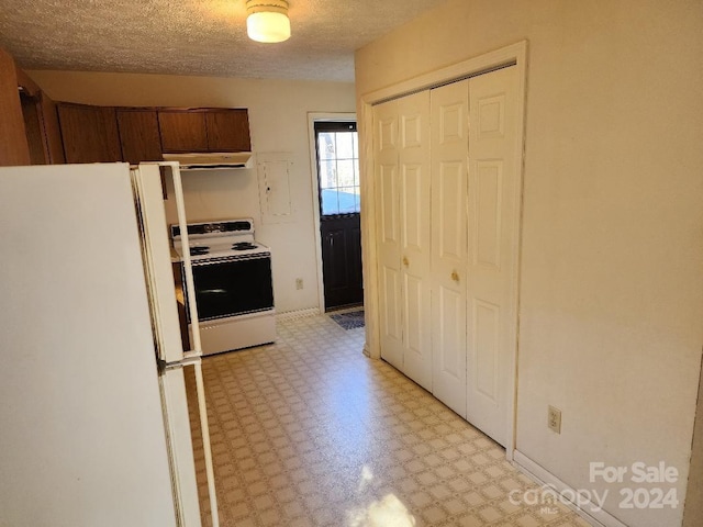 kitchen with a textured ceiling and white appliances