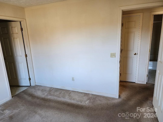 carpeted spare room featuring a textured ceiling