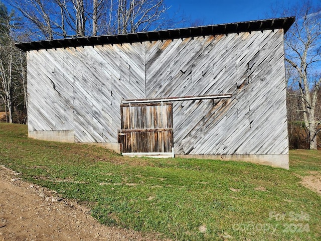 exterior space with an outdoor structure and a yard