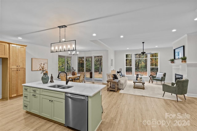 kitchen featuring a center island with sink, sink, stainless steel dishwasher, light hardwood / wood-style flooring, and decorative light fixtures