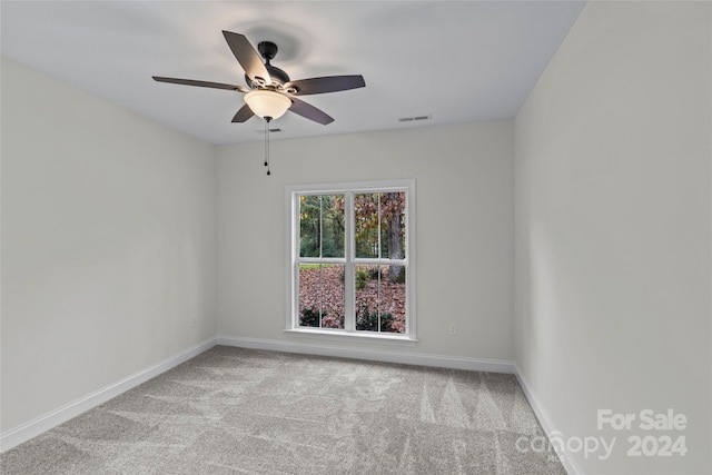 empty room featuring ceiling fan and light carpet