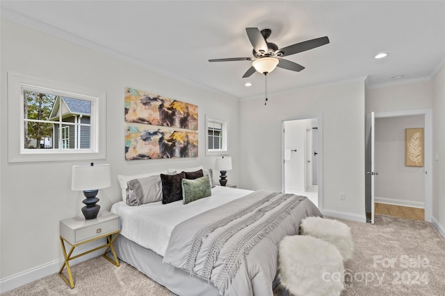 carpeted bedroom with ornamental molding, ensuite bath, and ceiling fan