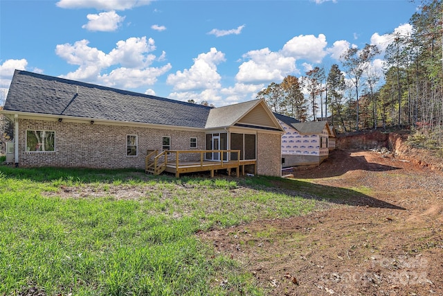 rear view of house with a deck and a yard