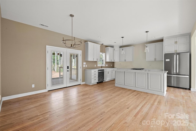 kitchen with white cabinetry, hanging light fixtures, stainless steel appliances, and a kitchen island