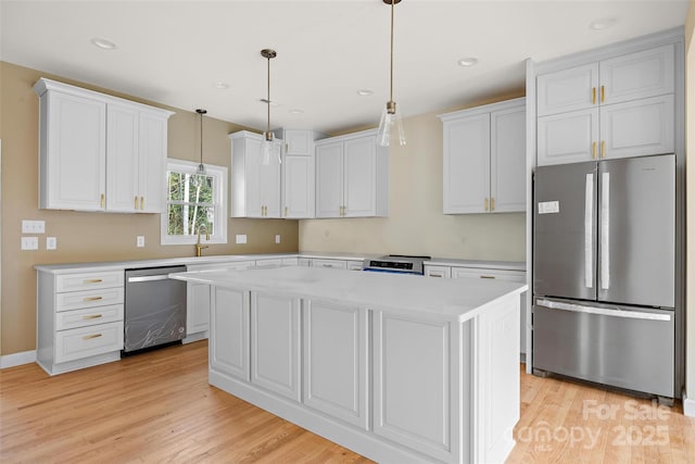 kitchen featuring white cabinetry, stainless steel appliances, hanging light fixtures, and a kitchen island