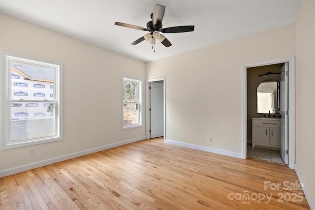 unfurnished bedroom featuring ceiling fan, sink, connected bathroom, and light wood-type flooring