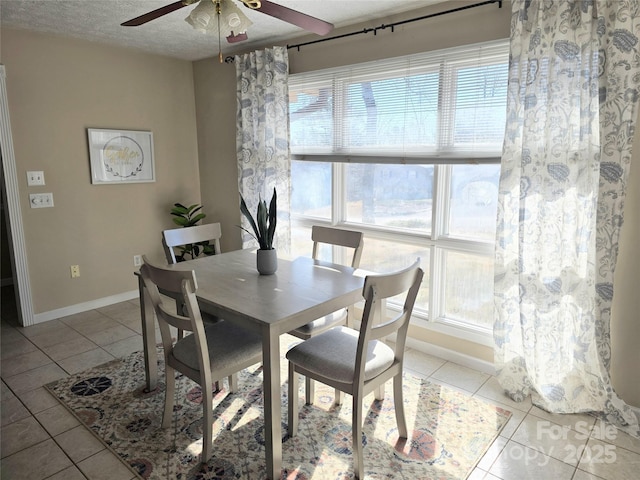 dining room featuring ceiling fan, light tile patterned floors, and a textured ceiling