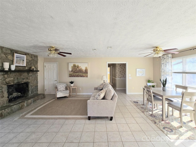 tiled living room with ceiling fan, a fireplace, and a textured ceiling