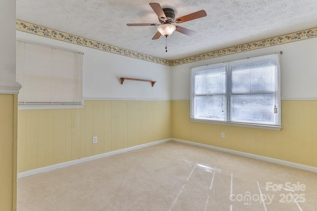 carpeted empty room with a textured ceiling and ceiling fan