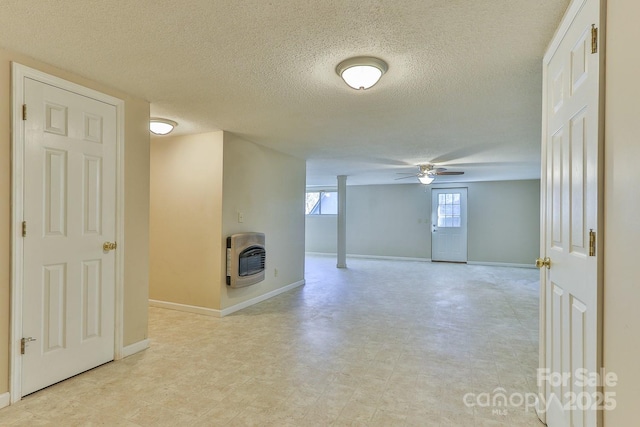 basement with heating unit, ceiling fan, and a textured ceiling