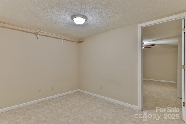 empty room featuring ceiling fan and a textured ceiling